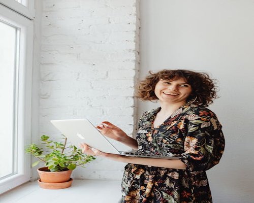 Person looking away from a laptop screen out a window